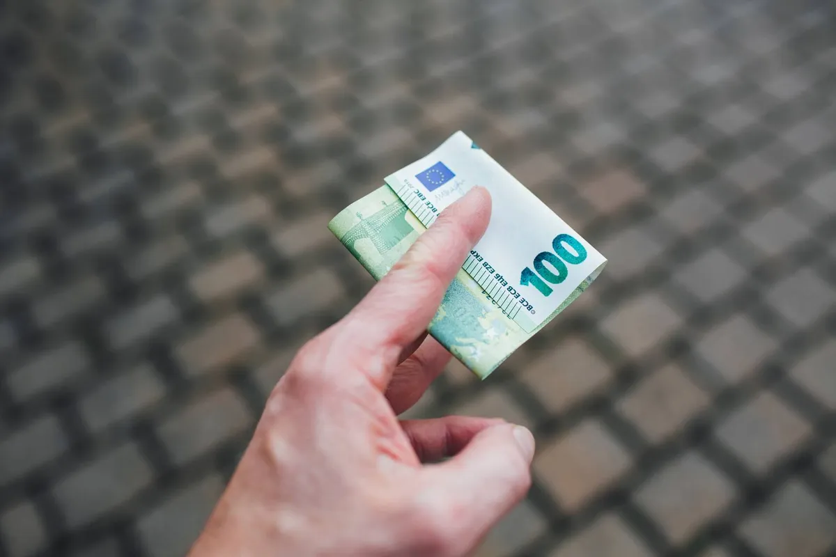 Mano sosteniendo billetes de cien euros
